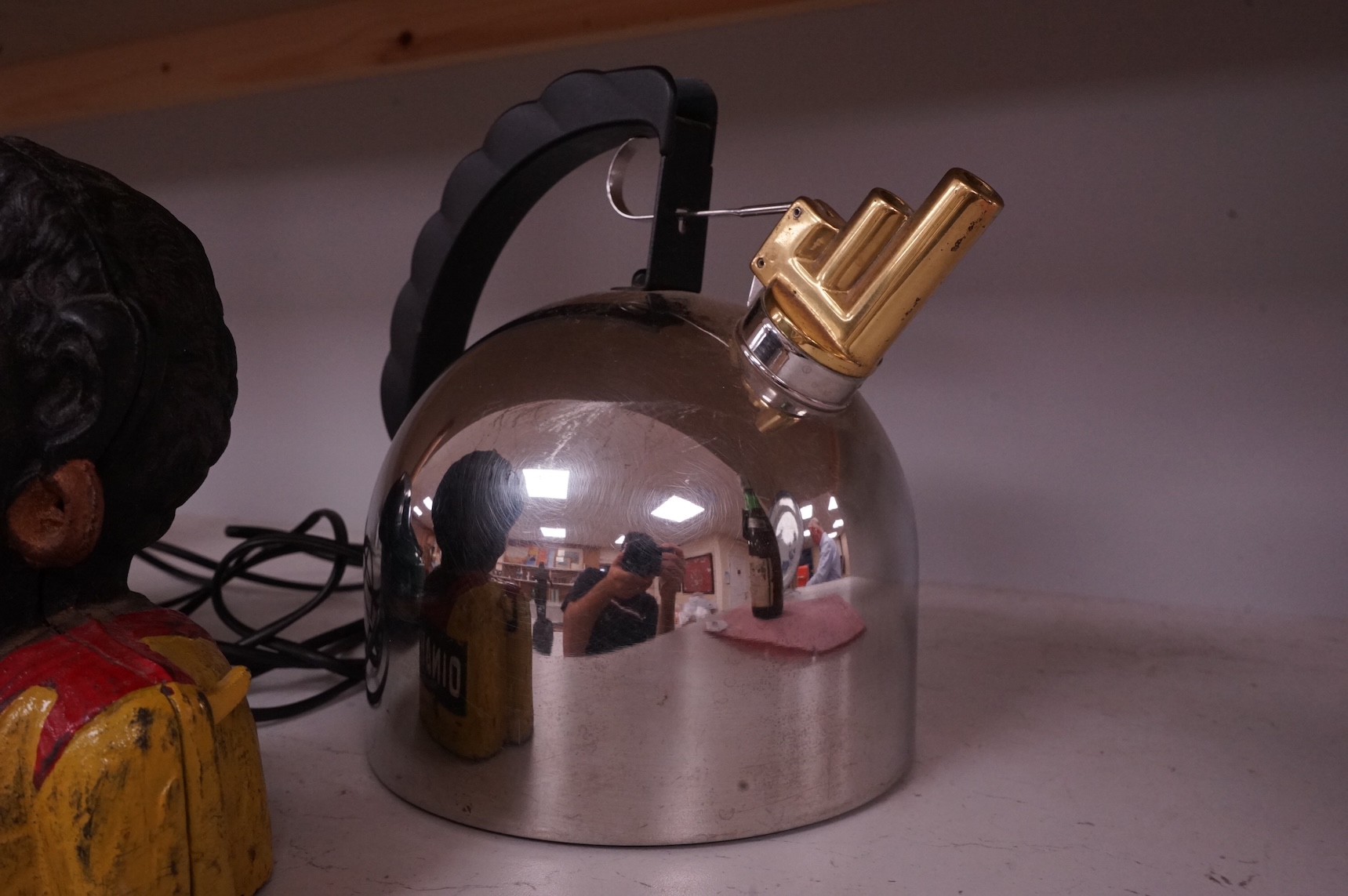 An Alessi 9091 kettle by Richard Sapper, an FTR green telephone and a painted cast iron mechanical money box. (3). Alessi kettle 22cm high.